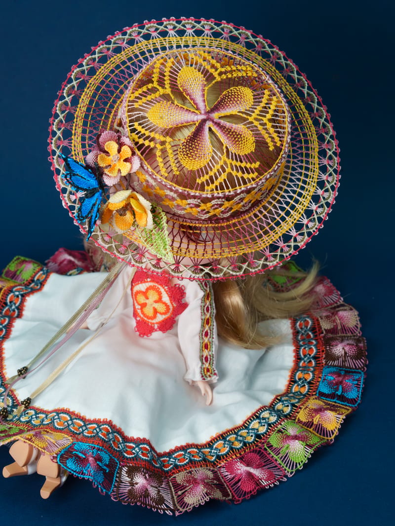 The hat seen from above against blue, its crown a five-petal rosette.